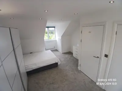 a small bedroom with a bed and a window at Hornchurch House - Jackson Close in Harold Wood