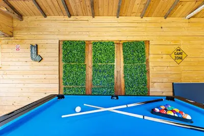 a pool table in a room with a wall at Spacious 4 Bed In Cambridge - Garden - Games Room in Cherry Hinton