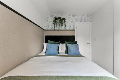 a bedroom with a large bed with blue pillows at Spacious 4 Bed In Cambridge - Garden - Games Room in Cherry Hinton
