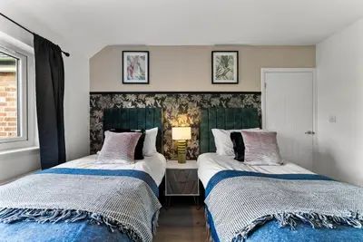 two beds sitting next to each other in a bedroom at Spacious 4 Bed In Cambridge - Garden - Games Room in Cherry Hinton