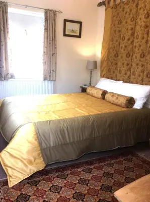 a bedroom with a large bed in a room at The Old Coach House in Bungay