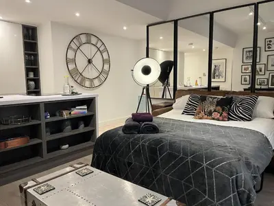 a bedroom with a bed and a large clock on the wall at Modern Ipswich Waterfront Apartment Free Parking - Long Term Stays Available in Ipswich