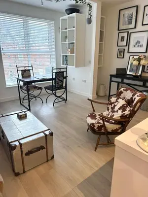 a living room with chairs and a table and a piano at Modern Ipswich Waterfront Apartment Free Parking - Long Term Stays Available in Ipswich