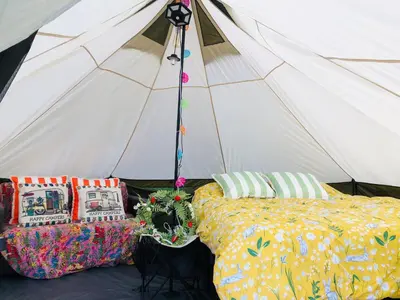a tent with two beds in front of it at HERTFORD Farm yurt Tent Camping fire pit bbq pet friendly in Hertford