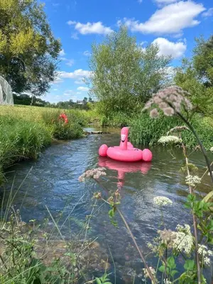 a pink inflatable raft in the middle of a river at HERTFORD Farm yurt Tent Camping fire pit bbq pet friendly in Hertford