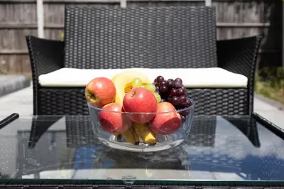 a bowl of fruit sitting on a glass table at Stunning Spacious 4 Bed bungalow in Southend-on-Sea