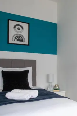 a bedroom with a bed with a blue and white wall at Stunning Spacious 4 Bed bungalow in Southend-on-Sea