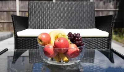 a bowl of fruit sitting on a glass table at Stunning Spacious 4 Bed bungalow in Southend-on-Sea
