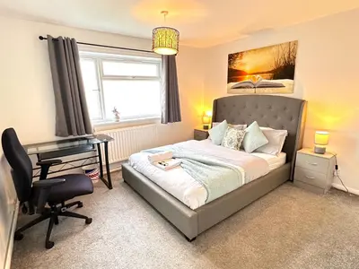 a bedroom with a bed and a desk and a computer at Colchester City Luxury With Free Parking and 5 G WIFI in Colchester