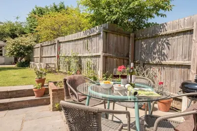 a patio with a table and chairs and a fence at Olive Cottage, Wickham Market in Wickham Market