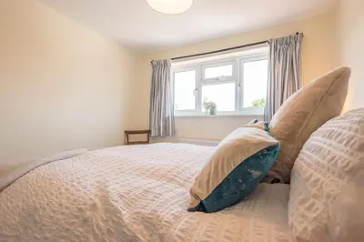 a bedroom with a bed with pillows and a window at Olive Cottage, Wickham Market in Wickham Market