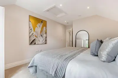 a bedroom with a large white bed and a mirror at Tailored Stays - Central Cambridge, Warkworth Lodge in Cambridge