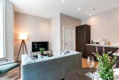 a living room with a couch and a tv at Tailored Stays - Central Cambridge, Warkworth Lodge in Cambridge