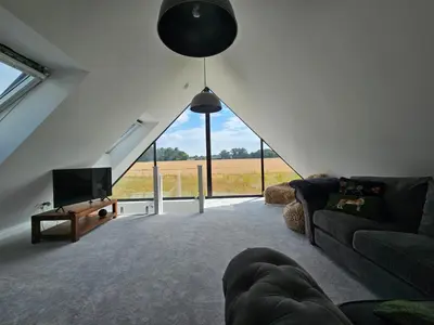 a living room with a couch and a tv at Field View in Elmswell