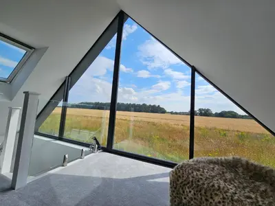 a room with large windows with a view of a field at Field View in Elmswell