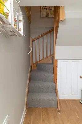 a staircase in a house with a gray carpet at The Retreat- amazing scenic views of the Essex countryside! in Salcott