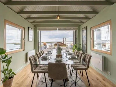 a dining room with a long glass table and chairs at The Pontoon - Pass the Keys in Southend-on-Sea