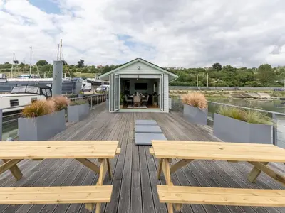 two benches on a wooden deck with a gazebo at The Pontoon - Pass the Keys in Southend-on-Sea