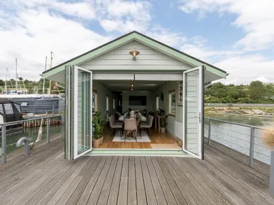 a covered deck with a table on a boat at The Pontoon - Pass the Keys in Southend-on-Sea