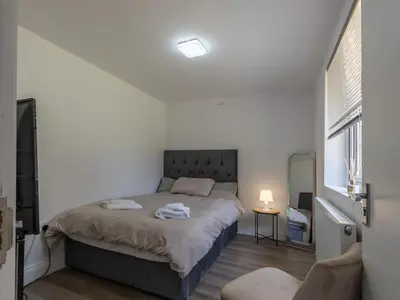 a bedroom with a bed in a white room at Comfortable 2 Bed Apartment Pass the Keys in Basildon