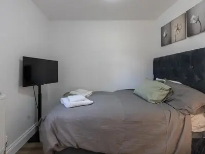 a bedroom with a bed and a flat screen tv at Comfortable 2 Bed Apartment Pass the Keys in Basildon
