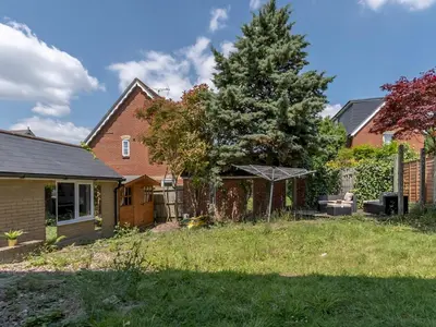 a backyard with a fence and a tree at Comfortable 2 Bed Apartment Pass the Keys in Basildon
