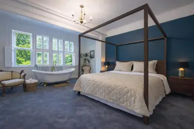 a bedroom with a bed and a bathtub and a bed and a bathtub at Willingham House Hotel in Willingham