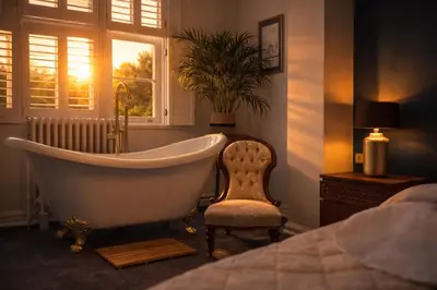 a bath tub in a bedroom with a chair and a window at Willingham House Hotel in Willingham