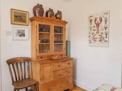 a wooden cabinet with vases on top and a chair at 1 Market Hill in Woodbridge