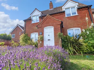 a brick house with purple flowers in front of it at 1 Market Hill in Woodbridge