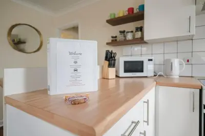 a white appliance sitting on top of a kitchen counter at Ely Stays Flat 1 in Ely