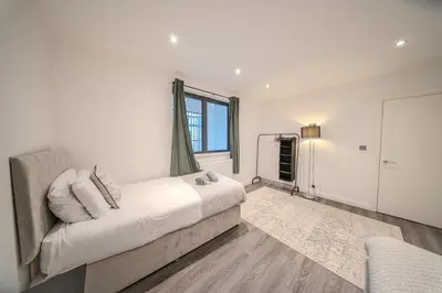 a white bedroom with a bed and a window at Royal Oak Apartments 9 - Free Secure Parking - 2 Bedrooms - Perfect for Contractors in Brentwood