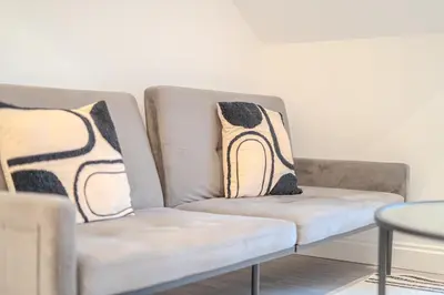 a couch with two pillows on it in a living room at Royal Oak Apartments 9 - Free Secure Parking - 2 Bedrooms - Perfect for Contractors in Brentwood