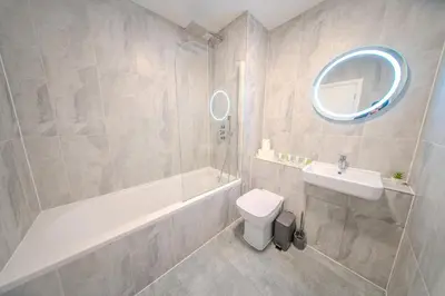 a bathroom with a tub and a toilet and a sink at Royal Oak Apartments 9 - Free Secure Parking - 2 Bedrooms - Perfect for Contractors in Brentwood