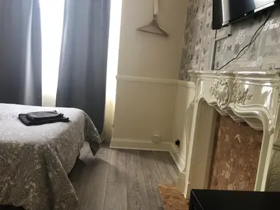a room with a bed and a fireplace with a television at Ac Lounge 36 Room A in Rochford