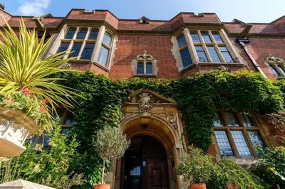 a large brick building with ivy growing on it at Westminster College Cottages, Cambridge in Cambridge