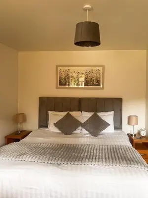 a bedroom with a large white bed with two lamps at Westminster College Cottages, Cambridge in Cambridge