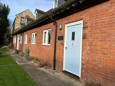 a brick building with a white door on it at Westminster College Cottages, Cambridge in Cambridge