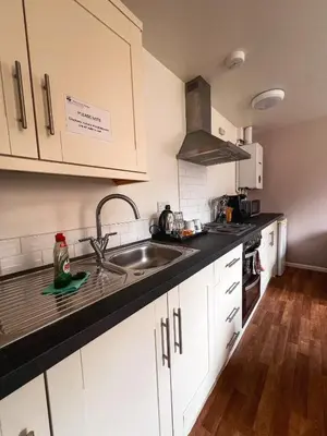 a kitchen with white cabinets and a sink at Westminster College Cottages, Cambridge in Cambridge