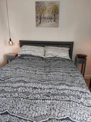 a bed with a blue and white blanket and two pillows at Rocklands Retreat in Rockland Saint Peter