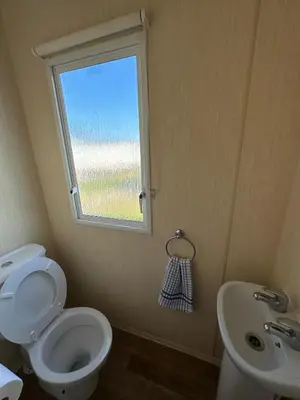 a bathroom with a toilet and a sink and a window at Seawick Holiday Home Horizon 363 in Saint Osyth