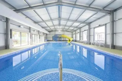 a large swimming pool with a yellow paddle in it at Seawick Holiday Home Horizon 363 in Saint Osyth