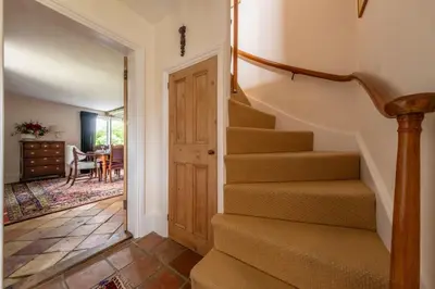 a hallway with stairs leading to a dining room at Cutbush Farm House in Hingham
