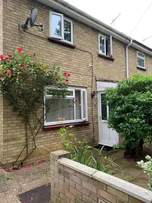 a brick house with a white door and a bush at Lawrence House in Cambridge