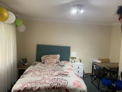 a bedroom with a bed with a green headboard and a table at Lawrence House in Cambridge