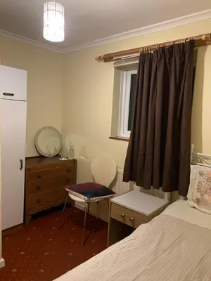 a bedroom with a bed and a dresser and a mirror at Lawrence House in Cambridge