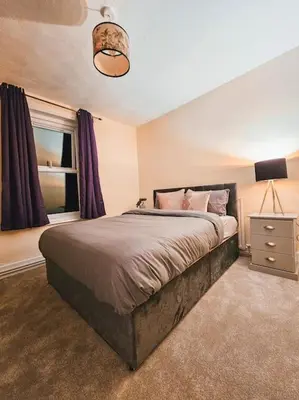 a bedroom with a large bed and a window at Spacious House in Ipswich in Ipswich