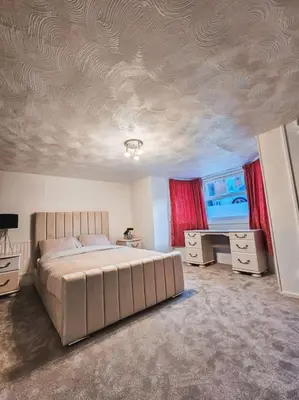 a bedroom with a bed and a desk and a ceiling at Spacious House in Ipswich in Ipswich