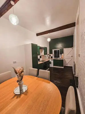 a dining room with a wooden table and a kitchen at Spacious House in Ipswich in Ipswich