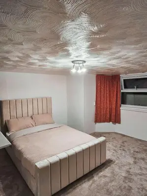 a bedroom with a bed in a room with a ceiling at Spacious House in Ipswich in Ipswich